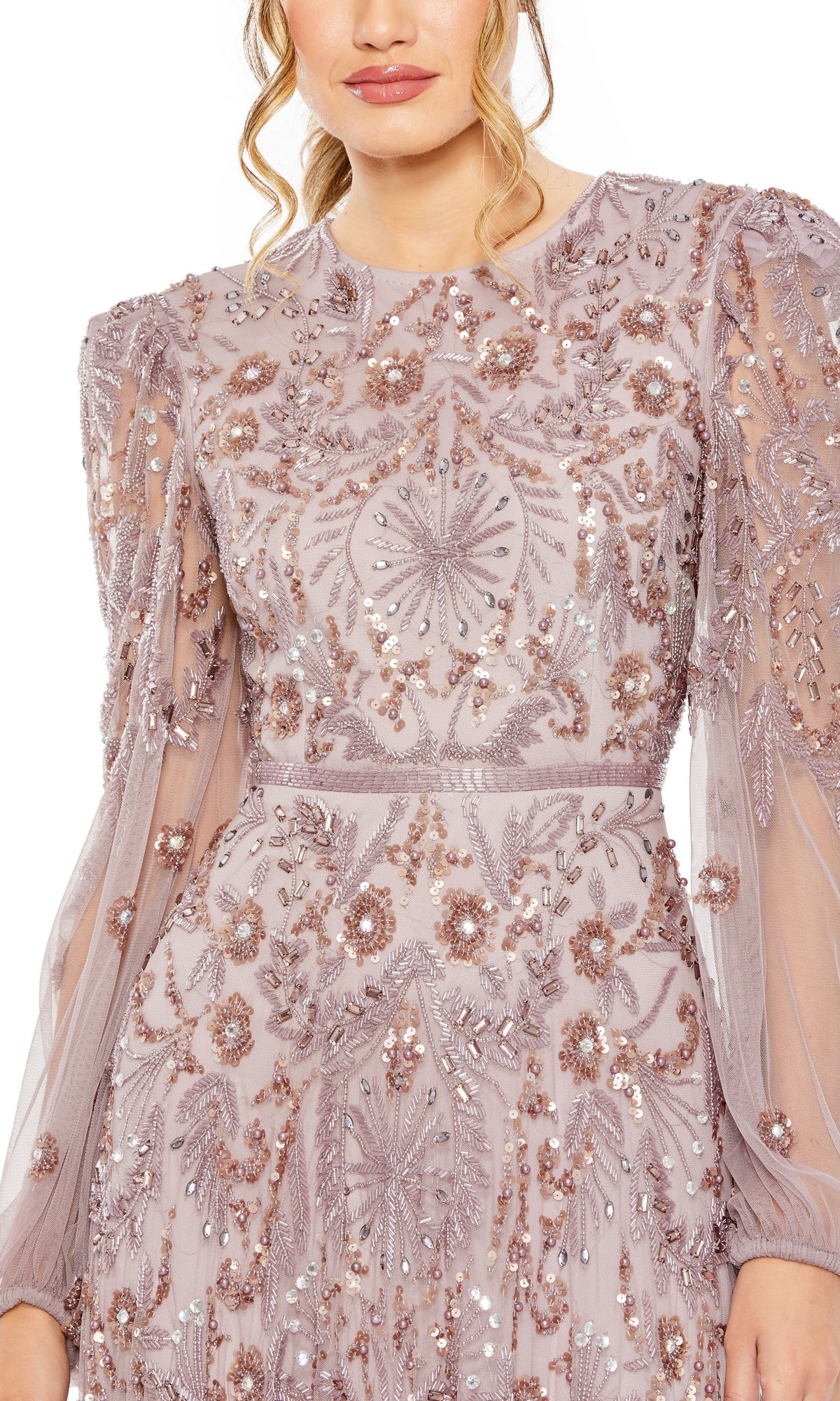 Woman models the Mac Duggal 93930 Long Sleeve Beaded Formal Gown in sheer mauve, adorned with intricate floral embroidery and sequin embellishments. Upper body shown; head partially out of frame.